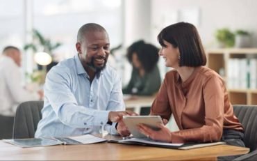 Business, people and banker with client on tablet at office for financial  support and loan advice. Employee, customer and smile on internet for mortgage options with investment, help or consultation