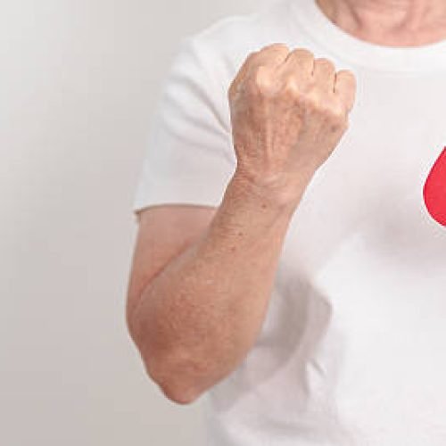 Elderly woman with red Blood drop paper for concept of June World Blood Donor day, Donation, April Hemophilia awareness day, May Thalassemia Day, Anemia awareness, June Sickle Cell and Blood Disorders
